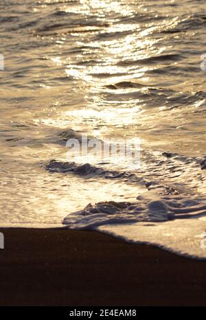 golden sea ripple, details of shiny water at the beach during sunset Stock Photo