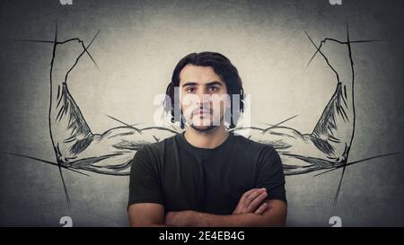 Confident guy, keeps arms crossed, strong personality, has no fears. Powerful person with biceps, muscular arms behind his back shows the inner streng Stock Photo