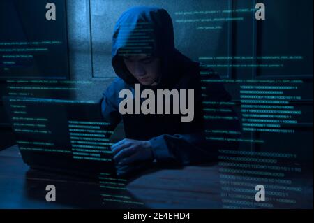 A Hacker is using laptop computer to steal data in the night Stock Photo
