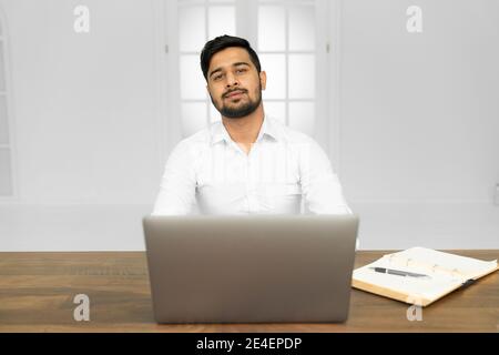 Portrait of confident indian business agent with laptop typing email feel positive want self-development on work stand in loft enterprise office Stock Photo