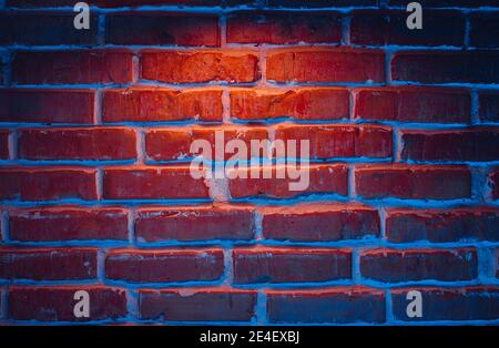 Brick wall texture background in red and blue neon lights Stock Photo