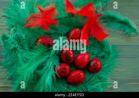 Macro photo of red easter quail egg. Painted red quail eggs on a green wood background. Easter Stock Photo