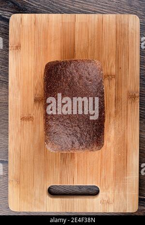 Top view of rye bread on a wooden cutting board. Top crust of rye bread. Stock Photo
