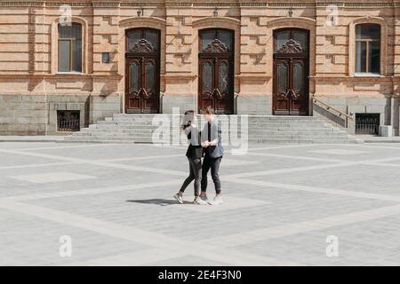 Valentines day celebration and dating outdoor concept. Happy loving couple dancing on the city street. Romantic couple spending time together in the Stock Photo