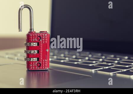 Red ruined padlock on a laptop keyboard. Computer security concept. Copy space. Stock Photo