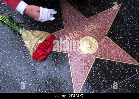 Los Angeles, California, USA. 23rd Jan, 2021. Flowers are placed at the star of Larry King on the Hollywood Walk of Fame, Saturday, Jan. 23, 2021, in Los Angeles. Former CNN talk show host and broadcasting legend Larry King died this morning at Cedars-Sinai Medical Center in Los Angeles. He was 87. King was hospitalized in late December after contracting COVID-19 and spent time in the hospital's intensive care unit. But no cause of death was released. Credit: Ringo Chiu/ZUMA Wire/Alamy Live News Stock Photo