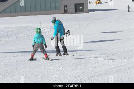 Gusar - Azerbaijan: January 2019. Little boy learning skiing with his father during winter holidays in Shahdag Mountain Resort Stock Photo