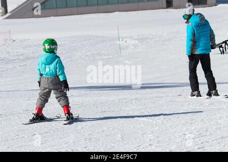 Gusar - Azerbaijan: January 2019. Little boy learning skiing with his father during winter holidays in Shahdag Mountain Resort Stock Photo