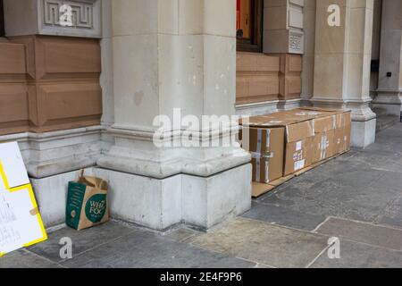 Take away paper carrier bag and cartoon box for homeless people in London Stock Photo