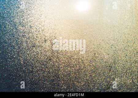 Misted window with drops of moisture that glows in the sun.Texture ...