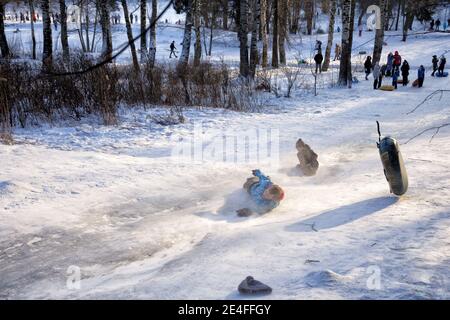 Russia. St. Petersburg. January 09.2021. Shuvalov park.Sledding from a high mountain.Both adults and children love to sled fast.People love extreme de Stock Photo