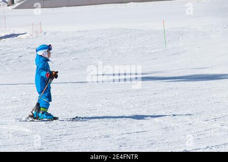 Gusar - Azerbaijan: January 2019. Child skiing in mountains. Ski race for young children. Winter sport. Little skier racing on snow Stock Photo