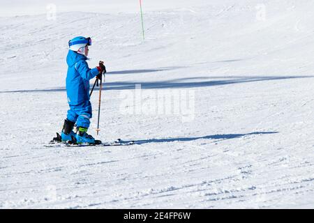 Gusar - Azerbaijan: January 2019. Child skiing in mountains. Ski race for young children. Winter sport. Little skier racing on snow Stock Photo