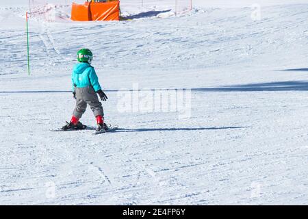 Gusar - Azerbaijan: January 2019. Child skiing in mountains. Ski race for young children. Winter sport. Little skier racing on snow Stock Photo