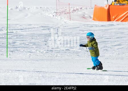 Gusar - Azerbaijan: January 2019. Child skiing in mountains. Ski race for young children. Winter sport. Little skier racing on snow Stock Photo