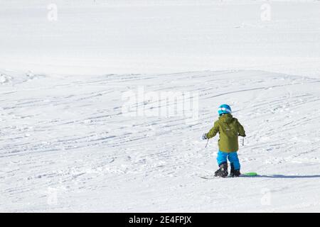 Gusar - Azerbaijan: January 2019. Child skiing in mountains. Ski race for young children. Winter sport. Little skier racing on snow Stock Photo