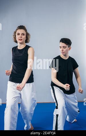 Female taekwondo instructor conducts personal training session for young woman at gym. Girl mastering new taekwondo moves during class with coach. Exe Stock Photo