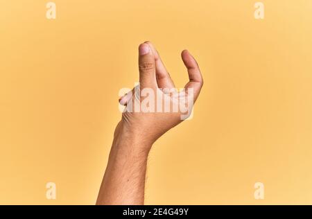 Arm and hand of caucasian man over yellow isolated background snapping fingers for success, easy and click symbol gesture with hand Stock Photo