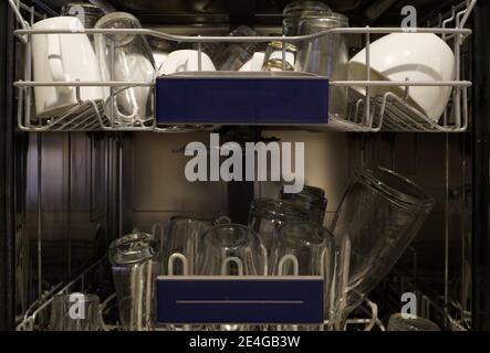 View inside dishwasher with fully of cup and glass bottle after finish. Stock Photo
