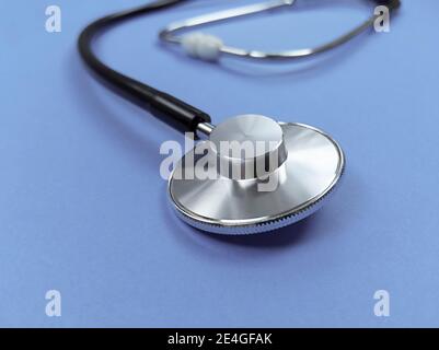 Black stethoscope on a violet background. Stock photo. Stock Photo
