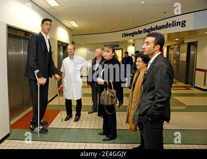 EXCLUSIVE. Turk Sultan Kosen, who is the current record holder of the tallest living man in the world as recognised by Guinness World Records, alongside Dutch endocrinologist Wouter de Herder, Chairman The European Neuroendocrine Tumor Society (ENETS) and German shoe manufacturer Georg Wessels (L, black leather jacket) at Erasmus MC hospital in Rotterdam, The Netherlands on November 9, 2009. Sultan is in Holland as part of a world tour to promote the Guinness Book of Records 2010. Born on September 27, 1982 in eastern Turkey, Sultan is 2,46m tall et has shoe size 60. Due to his extreme size he Stock Photo