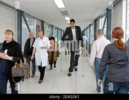 EXCLUSIVE. Turk Sultan Kosen, who is the current record holder of the tallest living man in the world as recognised by Guinness World Records, walks alongside Dutch endocrinologist Wouter de Herder, Chairman The European Neuroendocrine Tumor Society (ENETS) in Erasmus MC hospital in Rotterdam, The Netherlands on November 9, 2009. Sultan is in Holland as part of a world tour to promote the Guinness Book of Records 2010. Born on September 27, 1982 in eastern Turkey, Sultan is 2,46m tall et has shoe size 60. Due to his extreme size he never worked. Photo by Alain Gil Gonzales/ABACAPRESS.COM Stock Photo