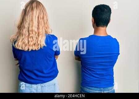 Young interracial couple wearing casual clothes standing backwards looking away with crossed arms Stock Photo