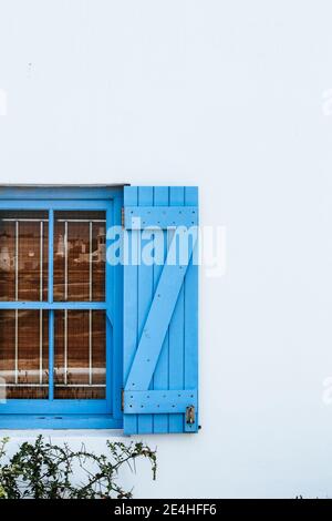 Close up of blue window shutters of a white mediterranean/nautical style white house on a sunny summer day Stock Photo