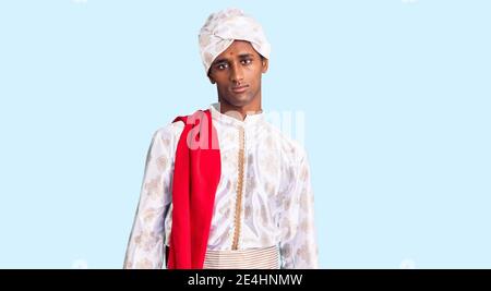 African handsome man wearing tradition sherwani saree clothes looking sleepy and tired, exhausted for fatigue and hangover, lazy eyes in the morning. Stock Photo