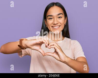 Young asian woman wearing casual clothes smiling in love doing heart symbol shape with hands. romantic concept. Stock Photo