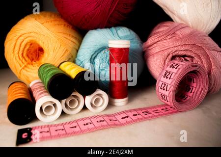 Multicolored objects of artisanal production such as: threads, needle and measuring tape. Line cones, green, yellow, red, orange, pink spools Stock Photo