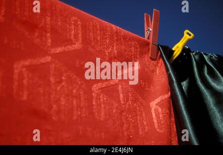 WASHING LINE WITH GREEN AND RED TABLE CLOTHS DRYING IN THE SUNSHINE. Stock Photo