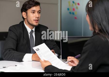 Human resource manager interviewing the male employment candidate in the office room. Happy job interview. Job application, recruitment and Asian Stock Photo