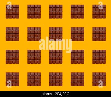 Pattern of chocolate bars against yellow background Stock Photo