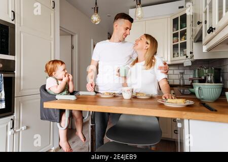 Happy family with baby daughter at kitchen table Stock Photo