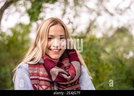 Blond woman with scarf in park during autumn Stock Photo