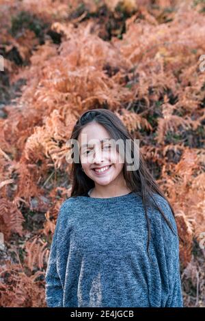 Portrait of long-haired teenage girl smiling at camera Stock Photo