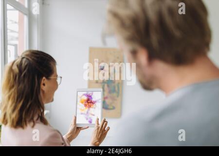 Woman and man using digital tablet in art gallery Stock Photo