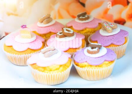 Pastry cupcakes with frosting in the form of pastry cakes and sweets. Stock Photo
