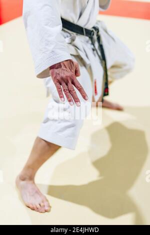 Mature man practicing karate on floor in health club Stock Photo