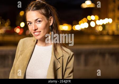 Young woman smiling while standing outdoors Stock Photo
