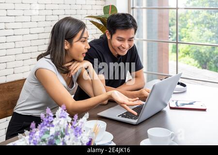 Asian man husband motivates advice wife woman freelancer working at home, give each other hi five Stock Photo