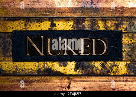 Nuked text on grungy textured authentic copper and gold background lined with bronze bars Stock Photo