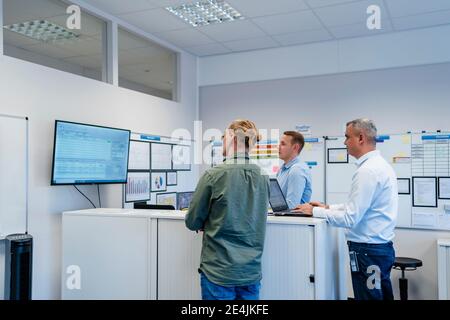 Businessmen studying plan while working together in meeting at office Stock Photo