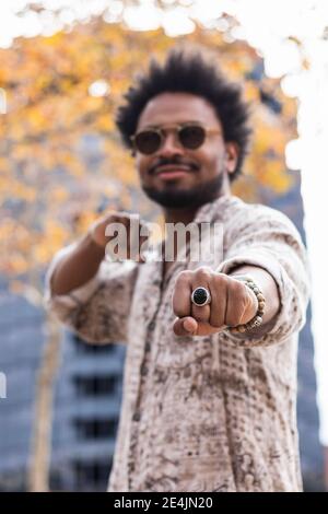 Close-up of stylish mid adult man wearing sunglasses gesturing while standing outdoors Stock Photo
