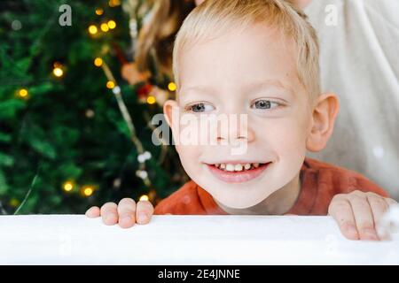 Close-up of cute smiling boy looking away at table Stock Photo