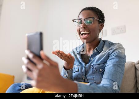Smiling woman having video call at home Stock Photo