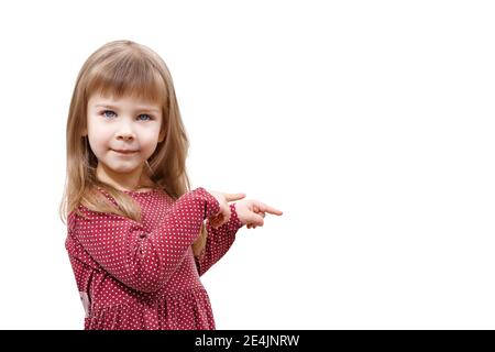 caucasian child girl in a red dress points her fingers to the background on the right. mock up with copy space. isolate on white background Stock Photo