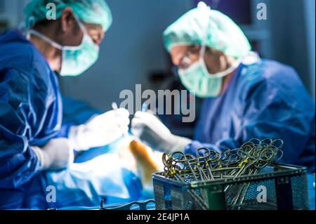Male orthopedic surgeon washing hand with soap by sink in hospital Stock Photo
