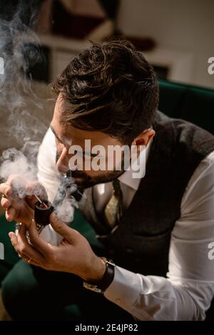 Bearded man smoking pipe Stock Photo